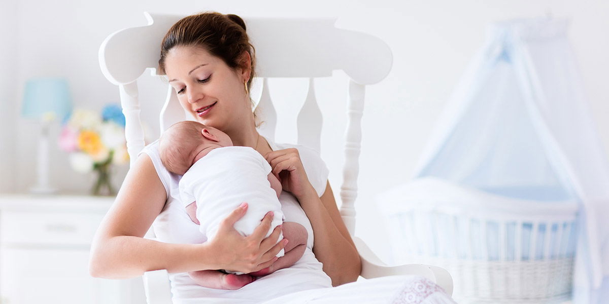 mama care sta pe scaun cu bebelusul in brate