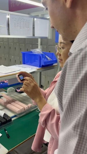 chinezoaica care ii arata lui Tudor ceasul pe linia de productie