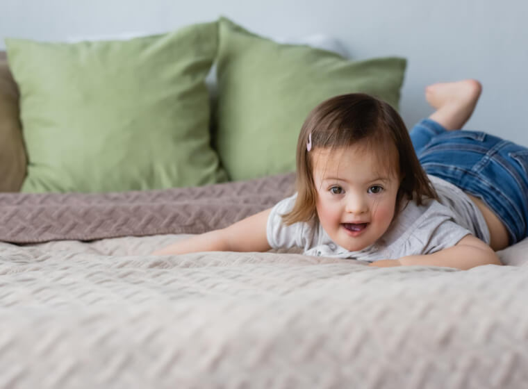copil mic care se joaca si sare in pat