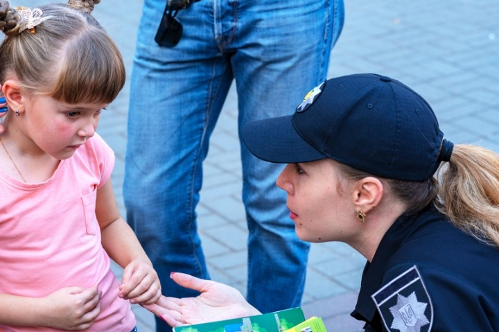 fetita care s-a pierdut si vorbeste cu o politista pe strada ca sa o ajute