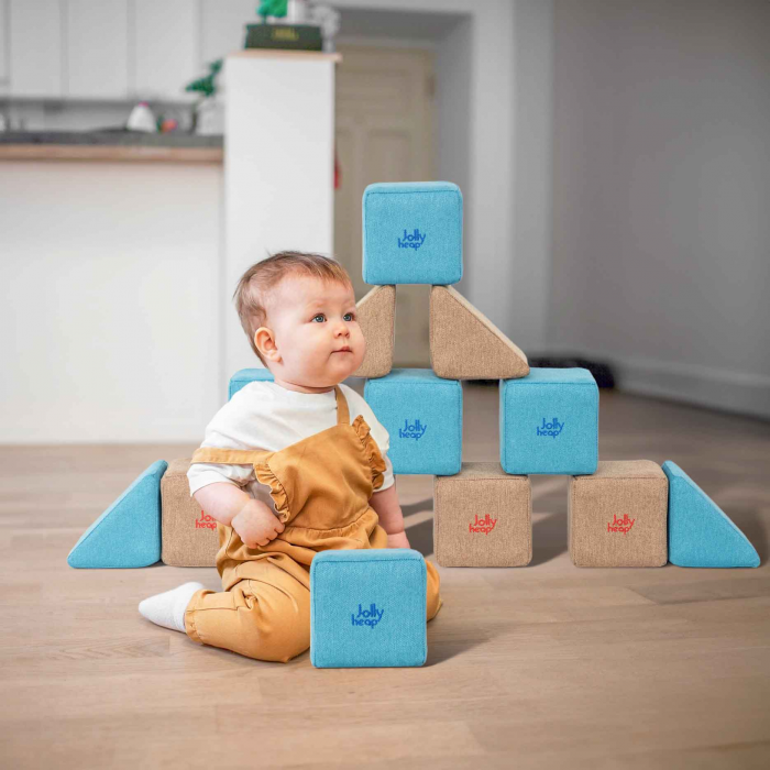 bebelus care sta langa o piramida facuta din cuburi jollyheap