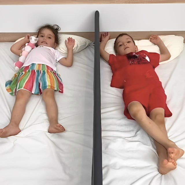 imagine cu 2 copii in patut separati de bariera separatoare de pat