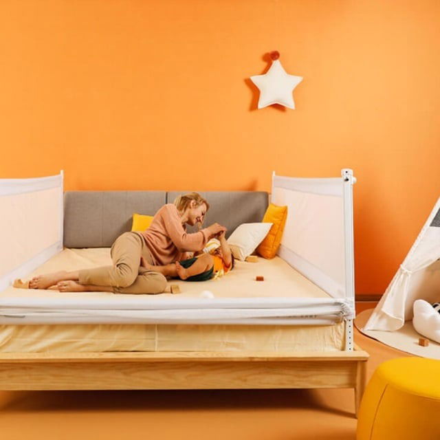 imagine cu mama si bebe in patul cu bariere de protectie pentru siguranta celui mic