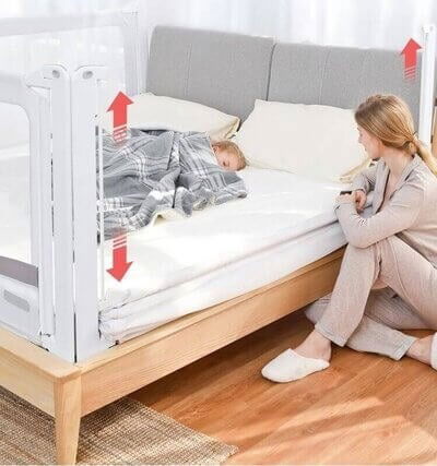 imagine cu copilul in pat si mama care sta alaturi, patul are protectii laterale pentru protectia celui mic