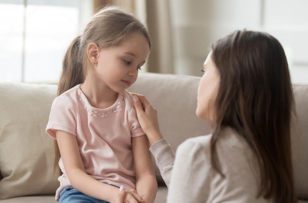 copil cu mama pe canapea vorbind despre cum sa procedeze in caz ca se pierde