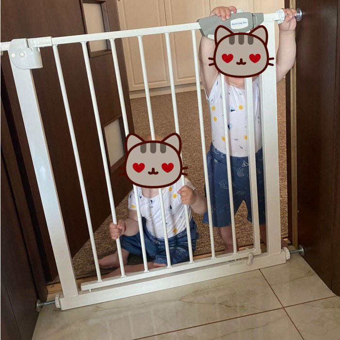 imagine cu doi copii care stau dupa poarta de siguranta de la empria