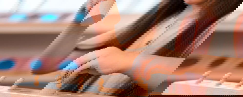 copil care face o activitate cu jucarii de lemn