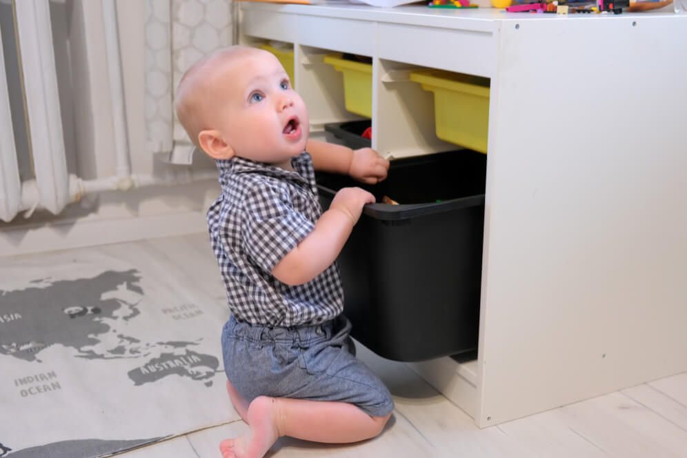 copil care cauta in sertar jucarii