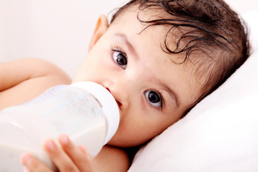 bebe care bea lapte din biberon