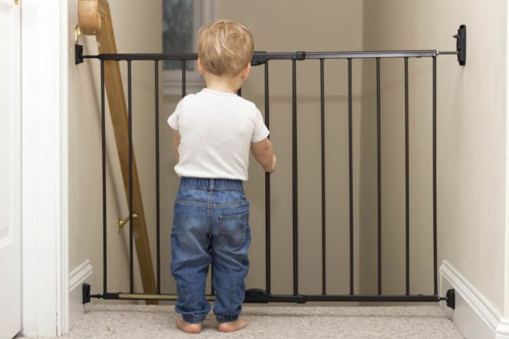 copil in fata scarilor blocate de o poarta de siguranta neagra