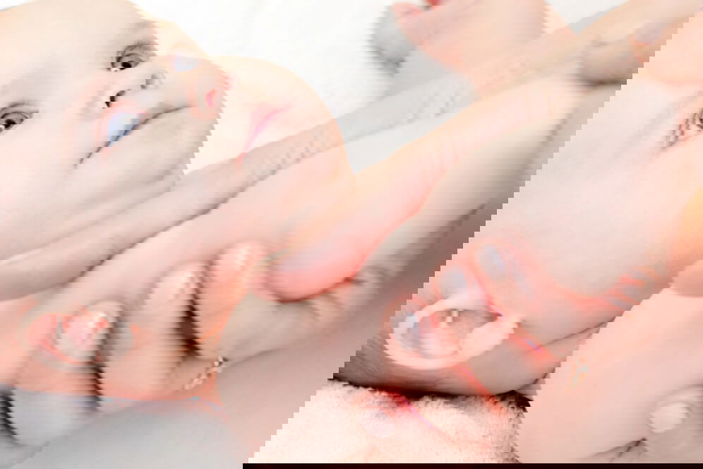 bebelus care sta la masat si este foarte atent la mama