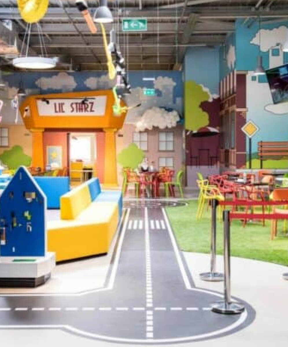 imagine din interiorul kiddobaneasa cu locul de joaca si o pista pentru masini