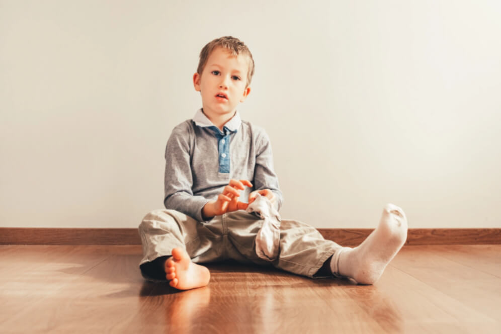 baietel care isi pune singur sosetele in picioare