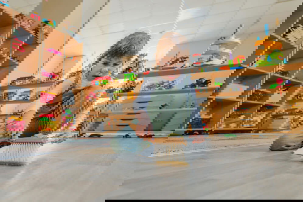 fetita care matura singura pe jos cu o perie