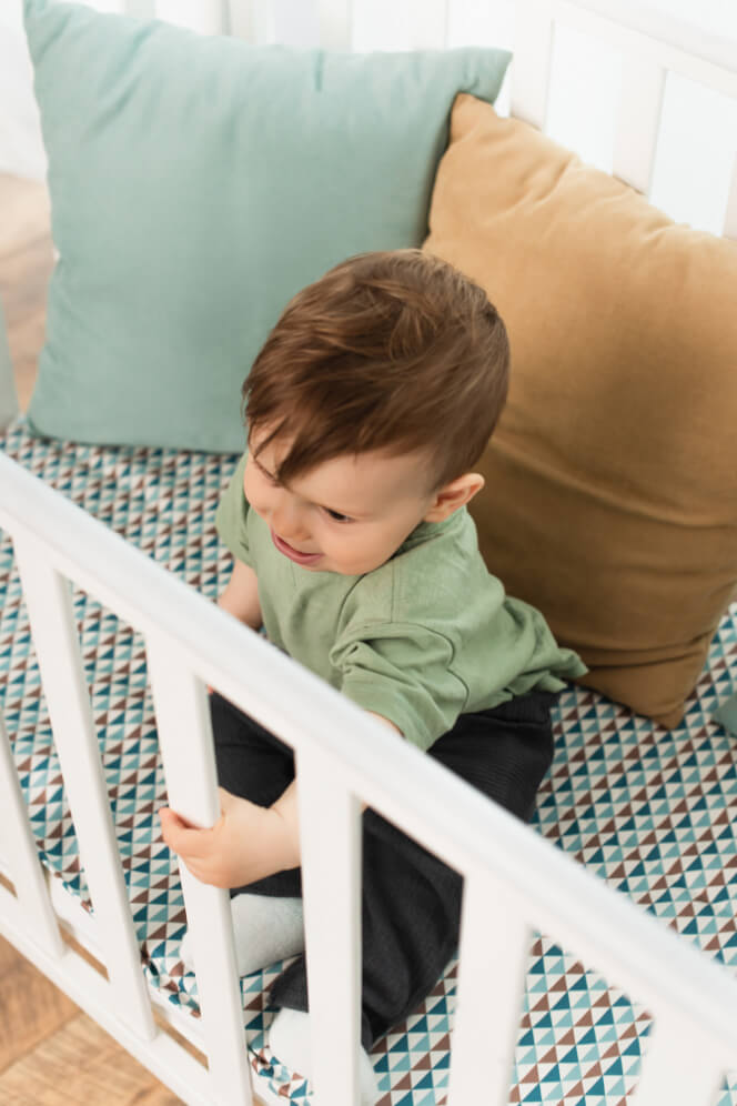 baietel mic in patul cu gratii