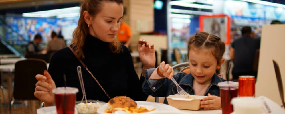 mama si fiica stau la masa in restaurant si iau cina