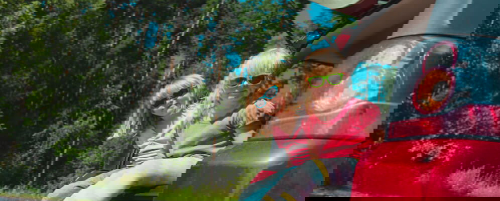 fetite care stau in spatele masinii pe portbagaj