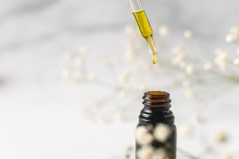 2. CBD pentru durere diferite afectiuni ce ar putea fi atenuate - pipeta cu ulei galben, o picatura deasupra sticlutei maro