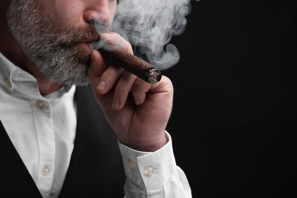 3. Cadouri pentru barbatii fumatori cu gusturi fine- barbat care fumeaza trabuc-min