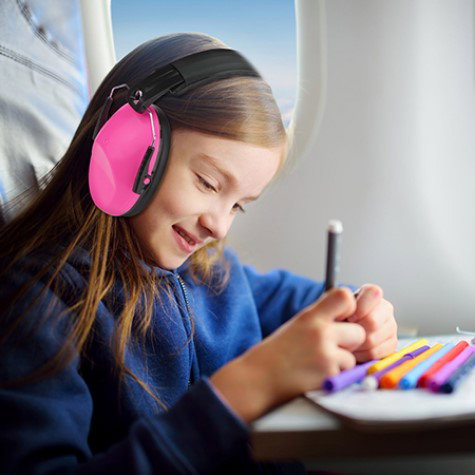 fata tanara cu casti antifonice roz in avion, coloreaza cu creioane colorate