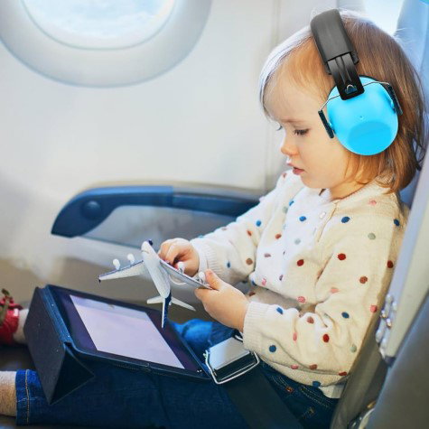 fetita cu casti antifonice albastre in avion