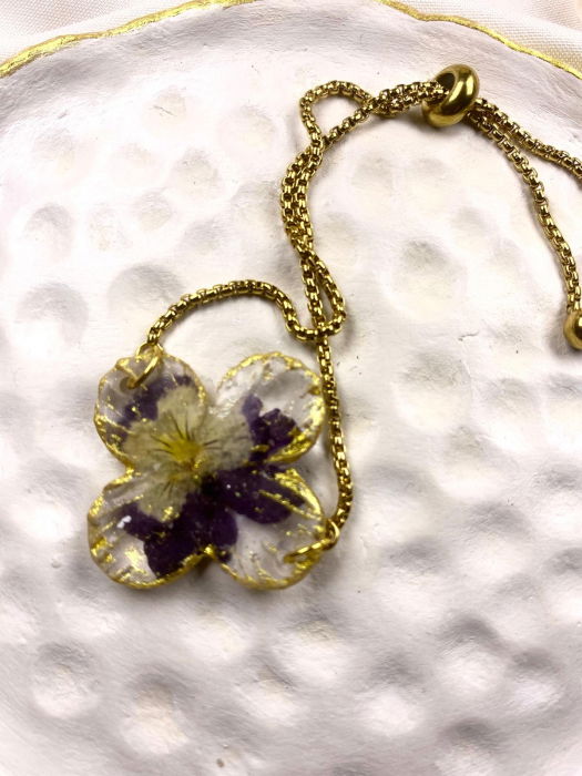 Bratara reglabila, aurie, decorata cu o panseluta montata in rasina. [1]