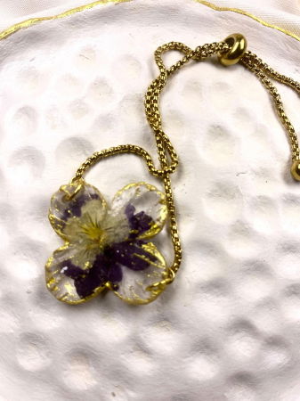 Bratara reglabila, aurie, decorata cu o panseluta montata in rasina.