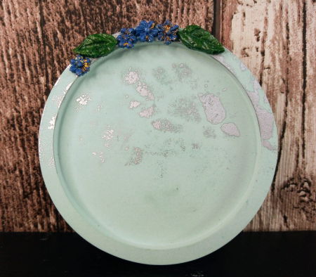 Suport rotund din ceramica decorat cu floricele.